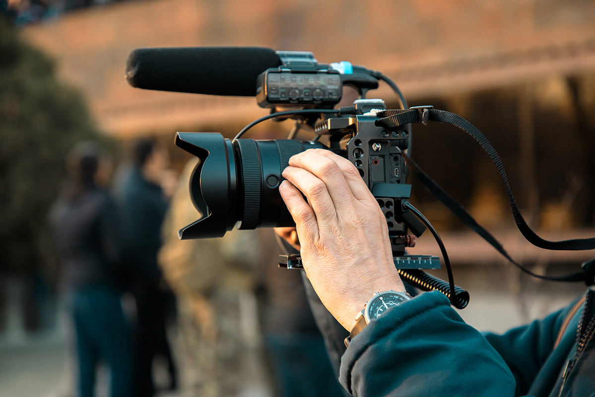 Man using a filming lens on his camera.